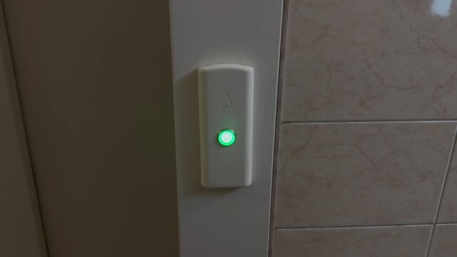 Illuminated Elevator Call Button Close Up
Close-up video of an illuminated elevator call button glowing on a wall panel. Modern building infrastructure, elevator system and urban interior concept.