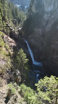 Sibe Br&uuml;nne Simme river source glacier water melting Switzerland deep forest, vertical video reel