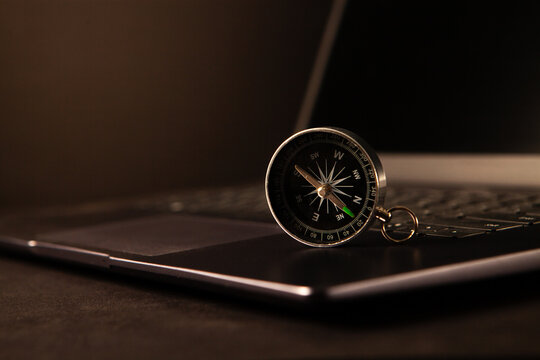 Compass on a laptop keyboard. Business and travel concept.