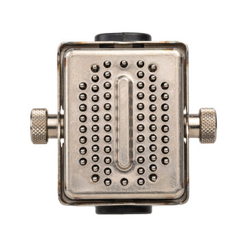 Rectangular metallic electronic component with a grid of small pins and side adjustment knobs isolated on a white background, for industrial use isolated on a transparent background