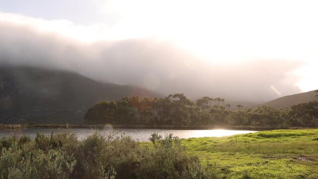 pond , grass , trees and Klein Mountains, Stanford, South Africa as the morning fog burns off
