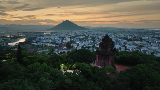 Aerial view of Nhan Tower overlooking Tuy Hoa city at sunset with Da Rang River and surrounding urban landscape, Dak Lak province, Vietnam.