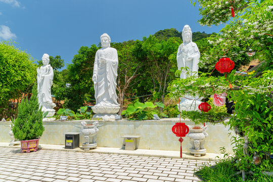 White statues of Buddha on blue sky background