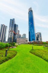 Obraz premium View of contemporary high-rise buildings across green lawn