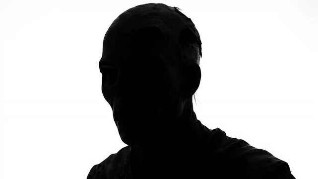 A dark silhouette of a man head and shoulders isolated against a bright white background for conceptual design