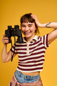 Joyful young woman embracing summer vibes with stylish outfit on a bright backdrop