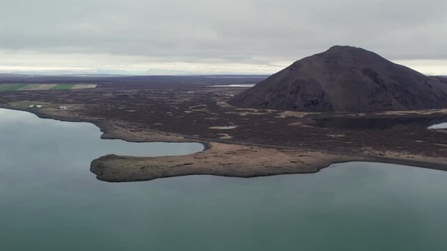 Drone footage flying over Lake Myvatn in Iceland. Millions of mosquitoes are flying over the water near the volcanic landscape