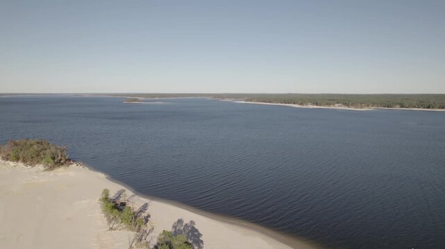 Aerial view of a beach near twin dikes park on Sam Rayburn Reservoir. Camera rises up.
