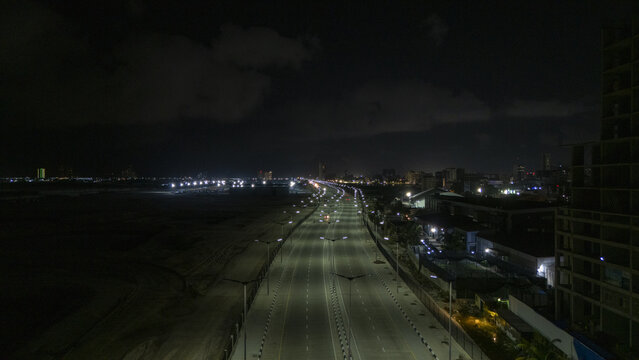 Aerial view of the illuminated Coastal Road at night with streetlights lining the empty highway and city lights in the distance Lekki, Lagos, Nigeria.