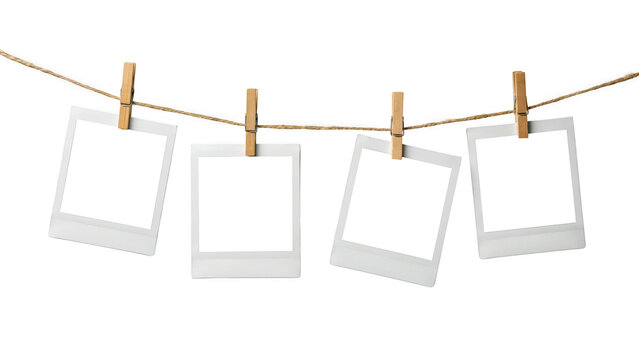 Four blank polaroid photos hanging on a rope with clips isolated on transparent background