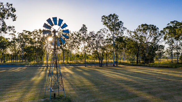 Metal windmill stands prominently in the foreground