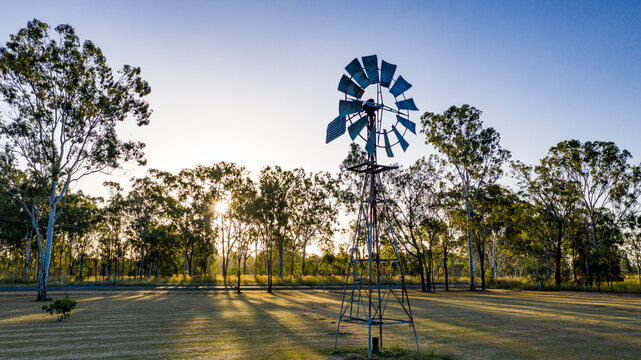 Metal windmill stands prominently in the foreground