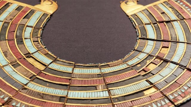 Closeup of ancient Egyptian broad collar pectoral necklace with gold turquoise and carnelian inlay from Tutankhamun treasure.