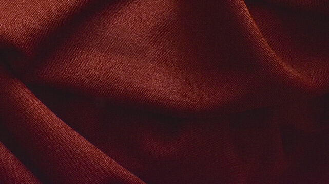 Terracotta burgundy fabric texture with soft elegant folds. Closeup abstract draped background of maroon or dark red luxury textile cloth with copy space