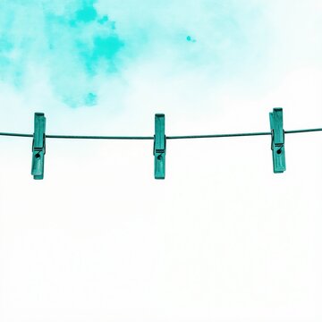 Three blue clothespins hang on a wire against a bright sky with watercolor clouds. Minimalist graphic design for laundry or baby shower themes.