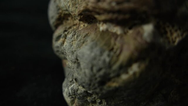 Tracking shot around weathered stone edge with dark background