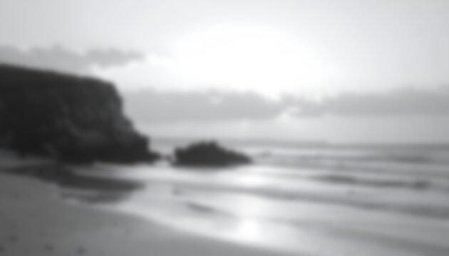 Moody black and white seascape at sunset with cliffs.