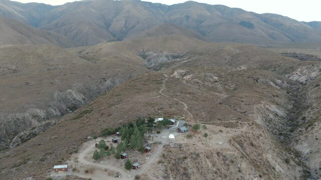 Drone aerial view of Observatorio Astronomico Ampimpa surrounded by rugged mountain landscapes in Tucum&aacute;n, Argentina.
