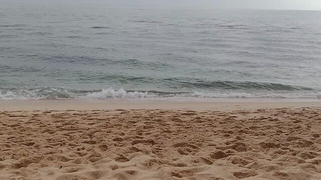 Waves roll onto the shore at a quiet beach during early morning hours