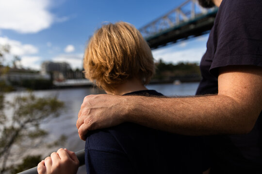 father's hand on his son's shoulder on a sunny day