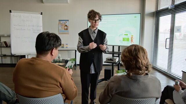 Zoom in shot of Female speaker distributing health brochures to diverse multiethnic audience during wellness seminar. Footage for medical marketing and dietary supplement commercials