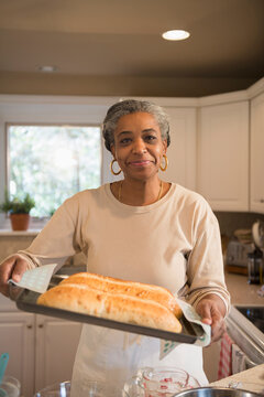 Portrait of smiling woman baking in kitchen