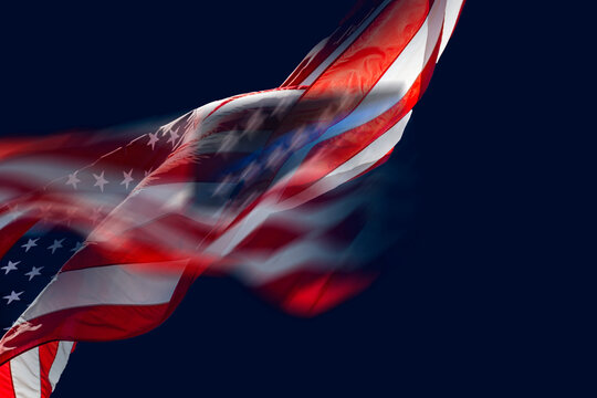 American flag waving against dark blue sky
