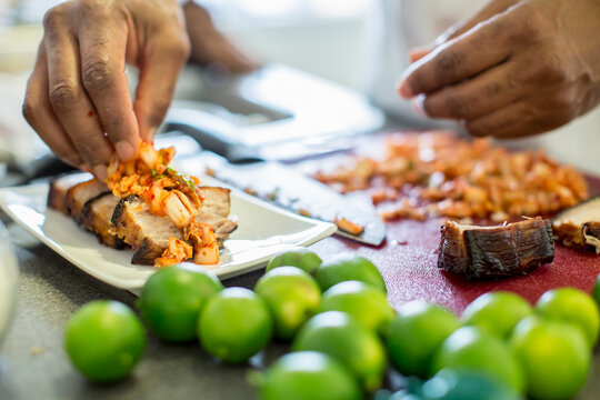 Close-up of chef making pork belly and kimchee in restaurant