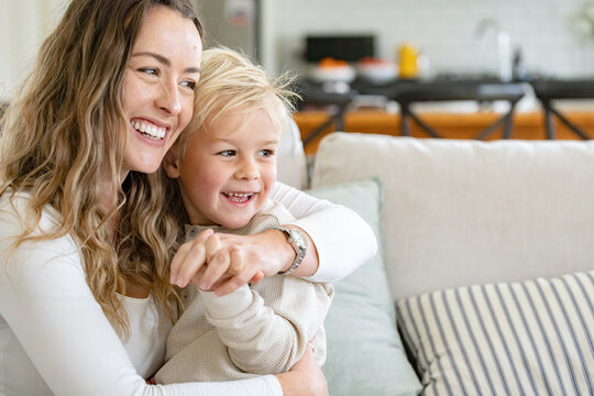 Mother cradles son on her lap in an embrace