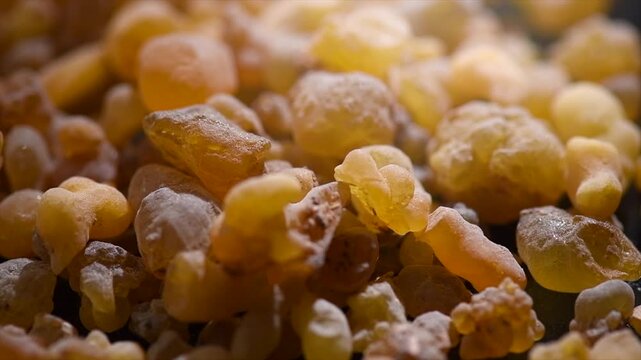 Olibanum Frankincense resin, Boswellia sacra background. Frankincense or olibanum aromatic resin for incense and perfumes, dark rotating backdrop, design, macro