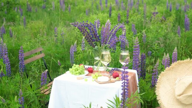 Table setting with food and wine among lavender flowers