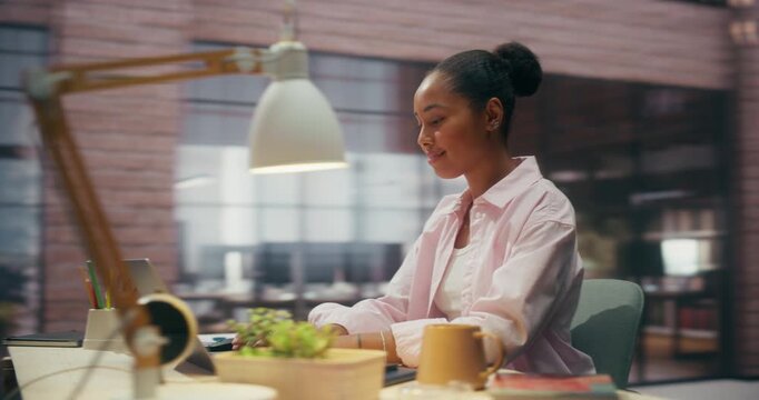 360 Degree. Focused Mixed Race Woman Types on Laptop in Office, Ecommerce Sales Charts and Financial Data While Writing Notes, Researching Business Growth and Payment Software. Arc Tracking Shot
