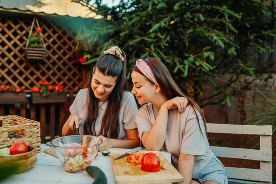 Women preparing fresh salad outdoors for healthy eating