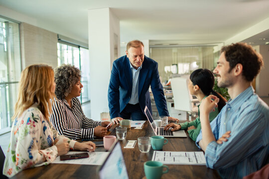 Manager leading diverse team meeting in modern office