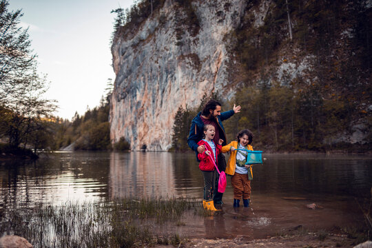 Father and children wading with nets in mountain lake