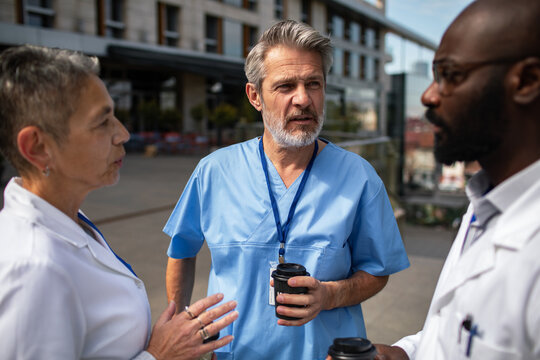 Doctors and nurses talking outside hospital during coffee break