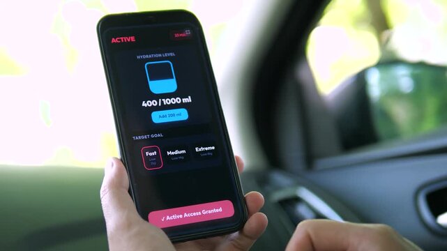 User selecting a Medium weight loss goal on a hydration app. Finger tapping between Fast and Extreme options. Ideal for fitness regimes, personalized health tracking, and goal-setting stock footage.