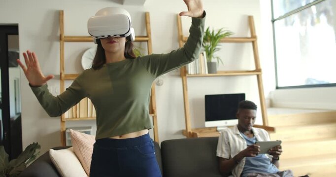 Couple woman wearing white VR headset navigating virtual interface after headset activation at home