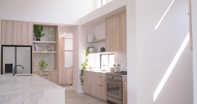 Sunlight is shifting in clerestory window, causing camera to pan, revealing marble island, cabinets