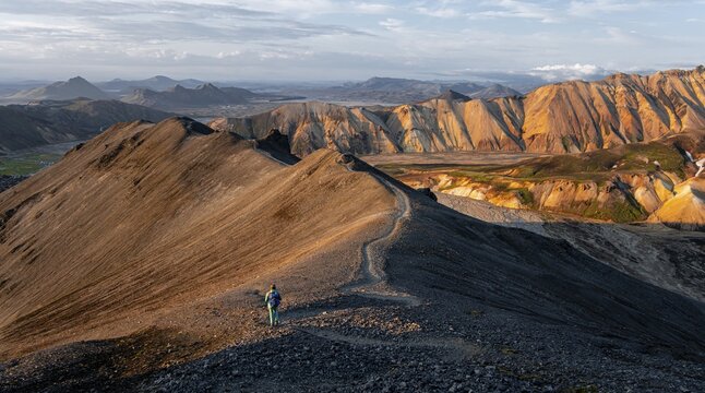 Hiker on the Laugavegur trekking trail, Laugavegur trekking trail, Dramatic volcanic landscape, Colourful erosion landscape with mountains, Lava field, Landmannalaugar, Fjallabak nature reserve, Su&eth;urland, Iceland