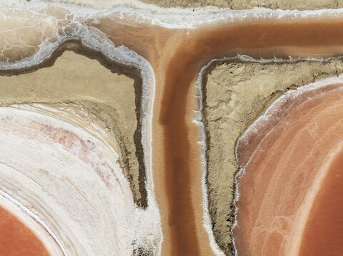 Saline ponds at the Bonanza salt works near Sanl&uacute;car de Barrameda. The reddish colour depends on the level of salinity and is directly caused by the algae Dunaliella salina and brine shrimp. Aerial view. Drone shot. C&aacute;diz province, Andalusia, Spain