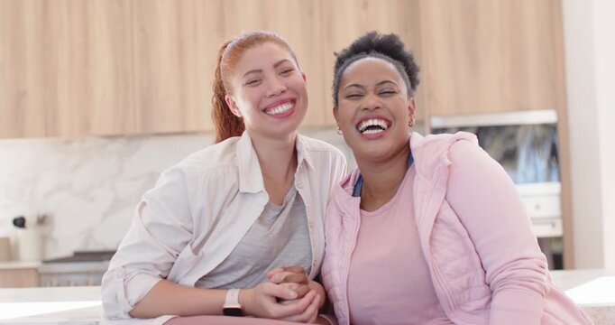 African American women posing for cam then holding hands, laughing, sharing joke on kitchen counter