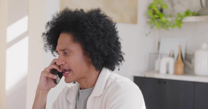 Cell ringing African American man holding cell to right ear listening talking in kitchen in fleece