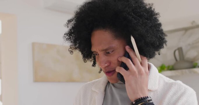 African American man holding phone answering call speaking adjusting grip stylus in home kitchen