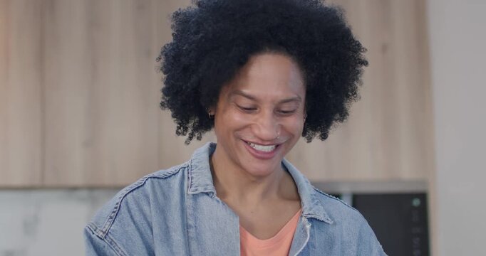 African American man in denim jacket smiling responding to offscreen voice and checking countertop