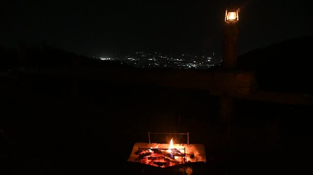 夜景が見えるキャンプ場とランタンと焚き火