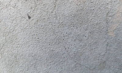 Fototapeta premium Weathered concrete wall texture with fine cracks, industrial gray cement surface background, gritty stone plaster material for architectural design
