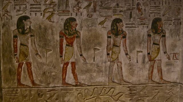 Close-up of ancient Egyptian relief carving inside KV17 tomb of Seti I, Valley of the Kings, Luxor, Egypt, showing a deity figure with black hair and deteriorating pigment.
