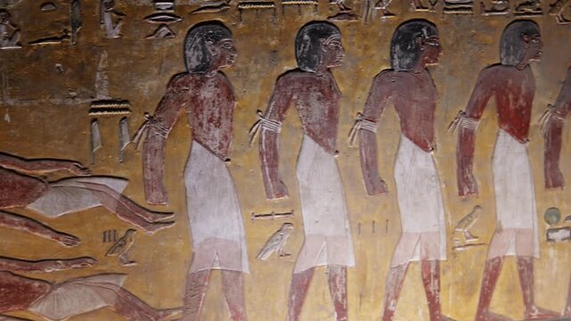 Close-up of ancient Egyptian relief carving inside KV17 tomb of Seti I, Valley of the Kings, Luxor, Egypt, showing a deity figure with black hair and deteriorating pigment.