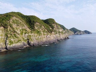 Obraz premium Aerial view of the rugged coastline and beautiful blue sea at Cape Tsutsuzaki on Tsushima Island, Nagasaki Prefecture, Japan.